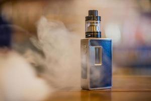 Electronic cigarette on a background of vape shop. E-cigarette for vaping. photo