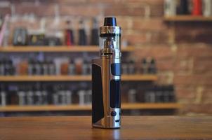 Electronic cigarette on a background of vape shop. E-cigarette for vaping. photo