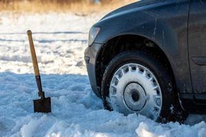 camión atascado en la nieve fuera de carretera a la luz del día con pala y enfoque selectivo foto