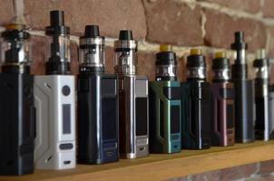 Electronic cigarette on a background of vape shop. E-cigarette for vaping. photo