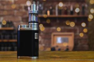 Electronic cigarette on a background of vape shop. E-cigarette for vaping. photo