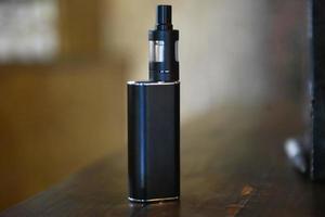 Electronic cigarette on a background of vape shop. E-cigarette for vaping. photo