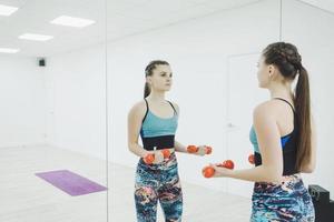 sporty woman lift dumbbells in the gym photo