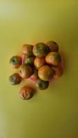 Several oranges on a pink plate on a yellow background 03 photo