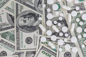 pills flat background, tablets laying on a us dollar banknotes - view from above photo