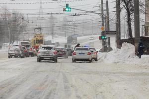 tula, rusia 13 de febrero de 2020 los coches de la ciudad se detuvieron en un cruce frente a los semáforos con un vehículo policial durante las fuertes nevadas. foto