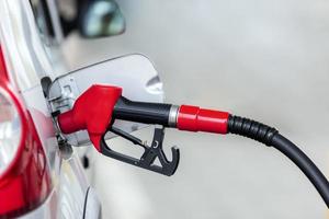 Silver car refuelling at the gas station, the concept of fuel energy photo