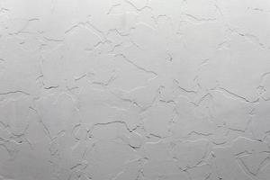 Abstract white unostentatious background and texture. A plaster wall with old cracked layer under new one. photo