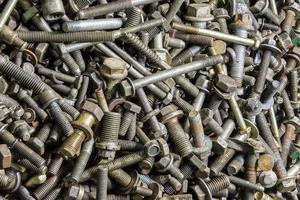 full frame background of used automobile bolts heap, old and dirty photo