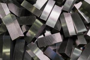 a pile of shiny faceted steel blocks - full frame close-up with selective focus photo