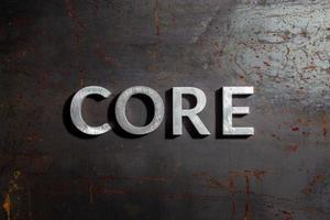 the word core laid with silver metal letters on rusted burnt iron flat surface background photo