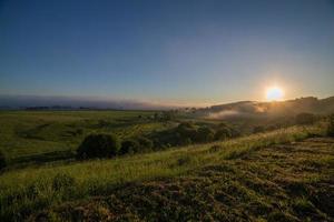 summer sunrise with distand fog in the middle of nowhere photo