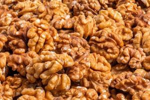 full frame close-up background of walnuts pile without shells photo