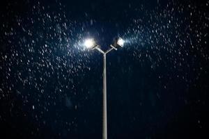 modern double light spot on lamp post at winter night snowfall photo