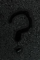 water drops on flat black rubber surface with the inscription - question mark photo