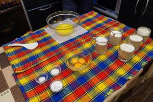 domestic sweet dough ingredients prepared on kitchen table with colorful cover photo