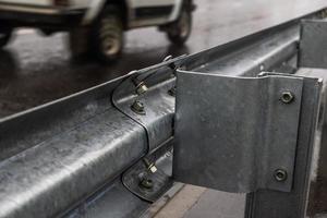 Tornillos y tuercas atornillados en la barandilla de la carretera foto