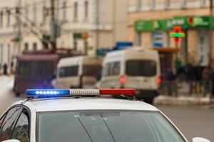 police car lights in city street with civilian cars traffic in blurry background in Tula, Russia photo