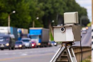 mobile speed camera device working on summer daytime road with blurry traffic photo