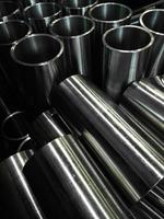 dark industrial background with cnc machined shiny steel pipes - selective focus and lens blur tech photo