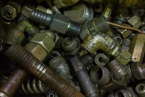a pile of old dirty hydraulic fittings and tube parts closeup with selective focus photo