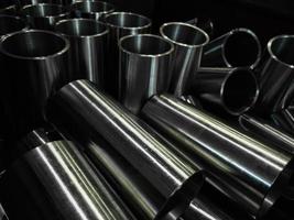 dark industrial background with cnc machined shiny steel pipes - selective focus and lens blur tech photo