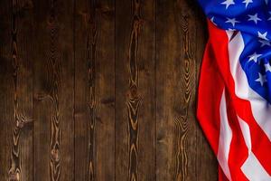 crumpled usa flag on flat textured wooden surface background photo