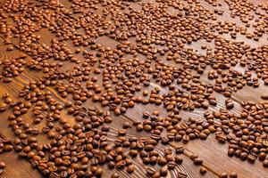 roasted coffe beans spreaded over wooden board - full frame background photo