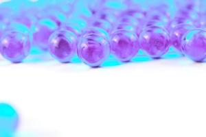 cyan spherical ball capsules with selective focus isolated on white background photo