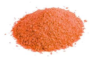 pile of dry orange chemical granules - close-up isolated on white background photo