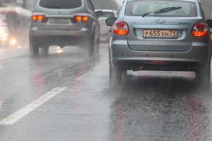 tula, rusia 14 de julio de 2020 automóviles que se mueven en la carretera asfaltada durante las fuertes lluvias de verano, vista desde atrás foto