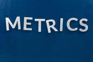 the word metrics laid with silver metal letters on classic blue surface - wtih careless dodging order photo