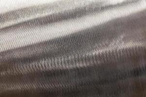 Close-up texture of flat steel surface manually cleaned with a flap wheel angle grinder. photo