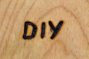 an abbreviation DIY - do it yourself - burned by hand with electrical woodburner on plywood surface photo