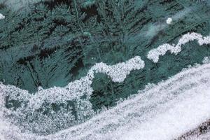 hoarfrost on car window glass at daylight close-up with selective focus photo