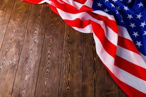 crumpled usa flag on flat textured wooden surface background photo