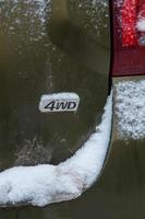 an abbreviation 4wd - Four-wheel drive - on dirty green car back photo