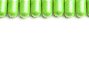 row of ufo green color organic capsules isolated on white background closeup with selective focus photo