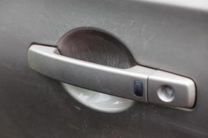 nail scratches on paint of car door handle photo