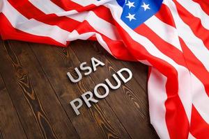 palabras usa orgullo colocadas con letras de metal plateado en una superficie de madera marrón con la bandera de los estados unidos de américa foto