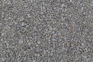 Dry white limestone ballast flat full frame background. Small gray dusty broken macadam stones texture. photo