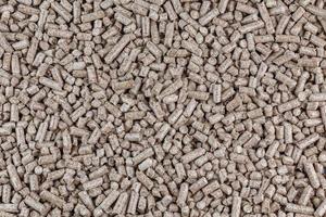 Compressed wooden sawdust pellets flat texture and background. Biofuel and pet litter, mulch. photo