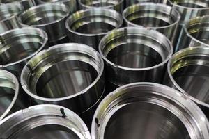 a close-up shot of shiny steel aerospace cnc turned tubes in a batch with selective focus and background blur photo