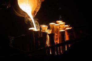 Industrial lost wax casting. The process of pouring for filling out ceramic shells with molten steel. photo