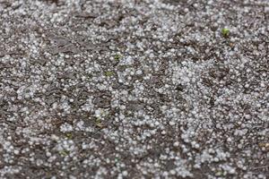 granizo de hielo blanco en la superficie de la carretera asfaltada foto