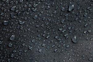 dark gray waterproof hydrophobic cloth closeup with water drops photo