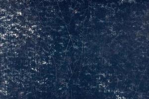 scratched dark blue surface of painted cardboard, flat full-frame background and texture photo