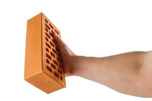 bare caucasian hand holding orange perforated clay brick - isolated photo