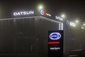 Datsun logo on car dealership building at foggy night - Datsun is an automobile brand owned by the Nissan Motor Company photo