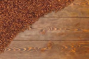 roasted coffee beans laid on brown wooden table surface photo